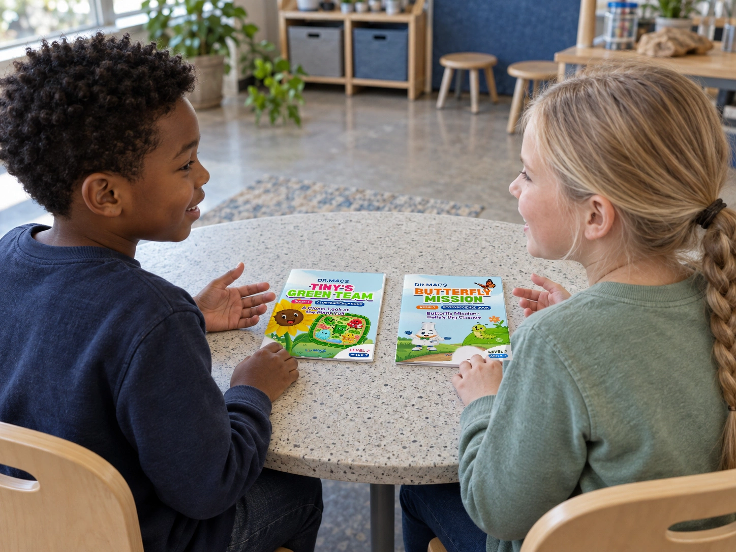 Two children compare the plant-cell and butterfly mission workbooks at a table.